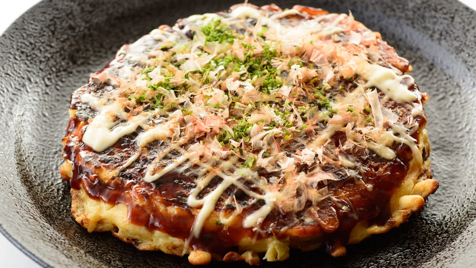 Okonomiyaki với lớp bánh mềm, topping đa dạng và sốt đặc trưng hấp dẫn