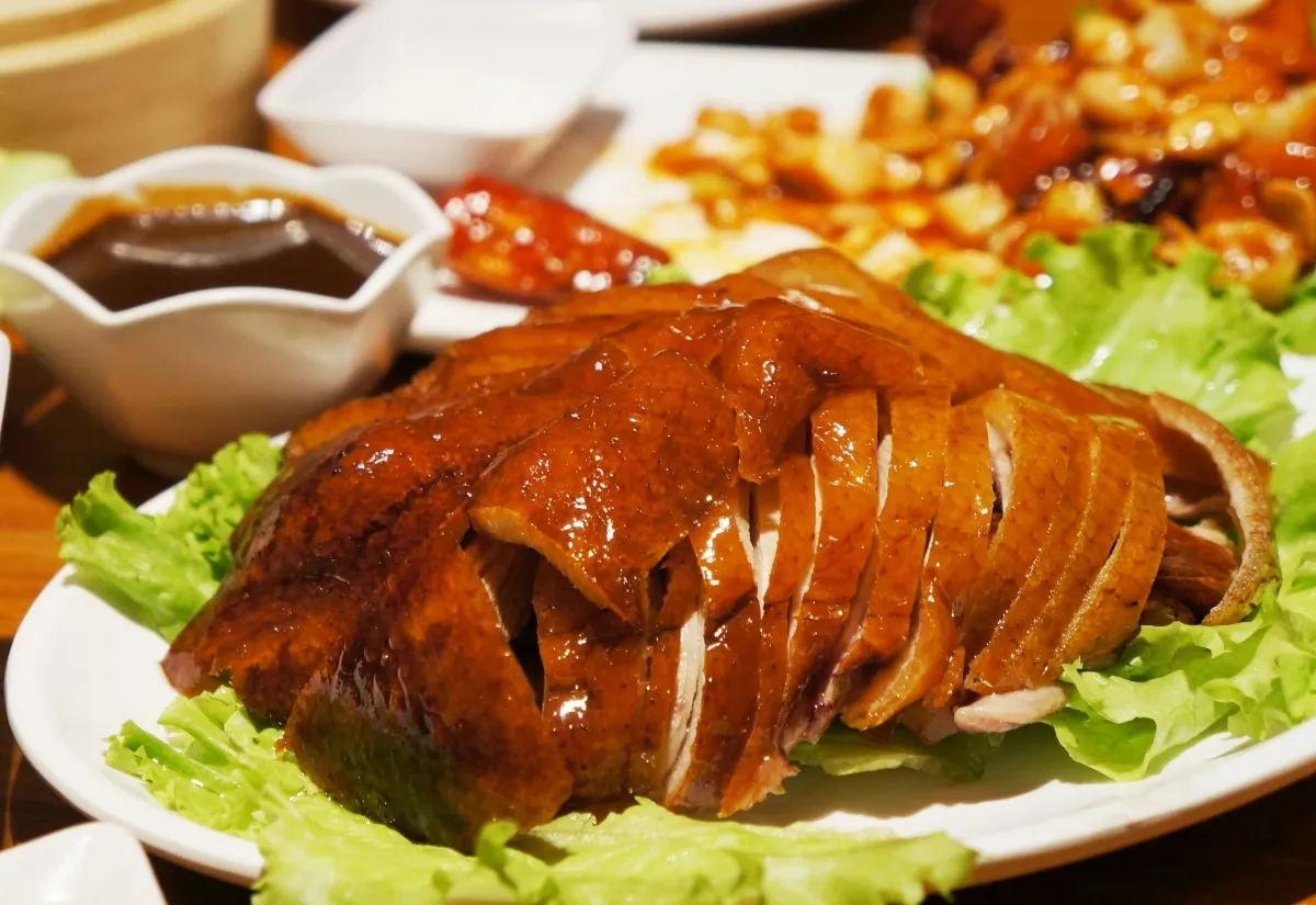 Vịt quay Bắc Kinh nổi bật với lớp da giòn mỏng và phần thịt mềm ngọt bên trong.